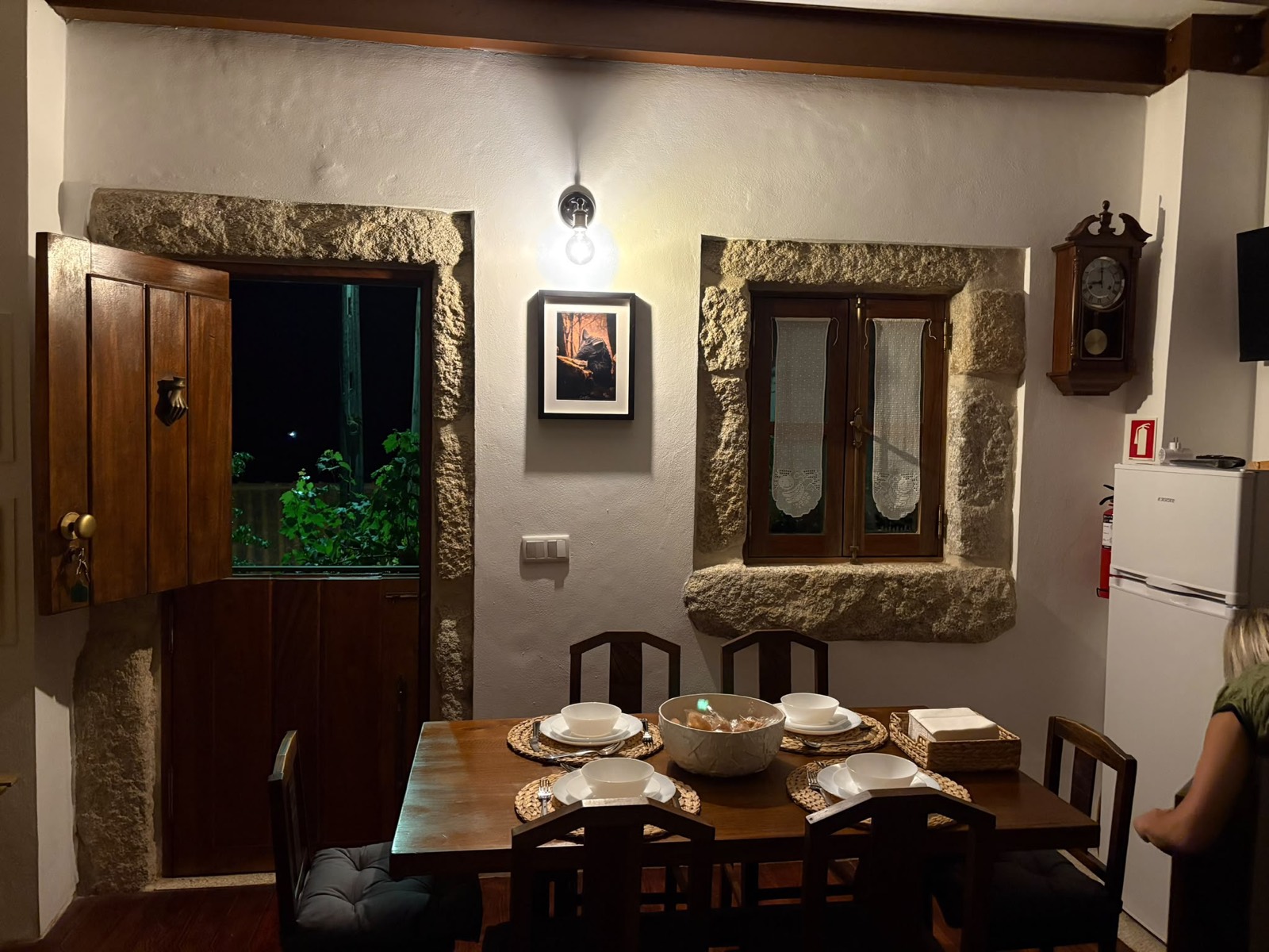 Sala e cozinha do T1, junto à lareira em pedra